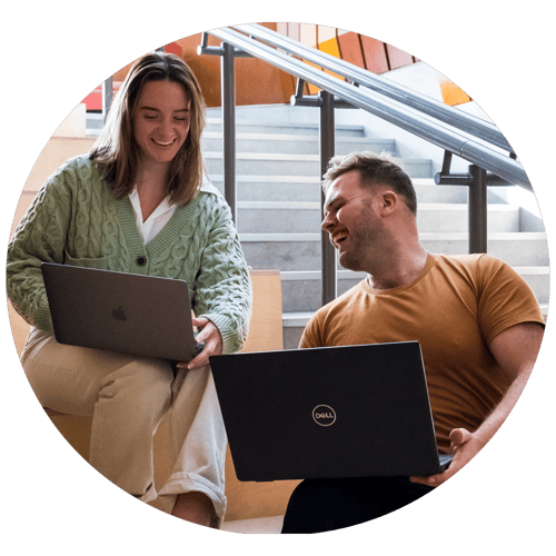 Circle Luke and Christina looking at laptops and laughing